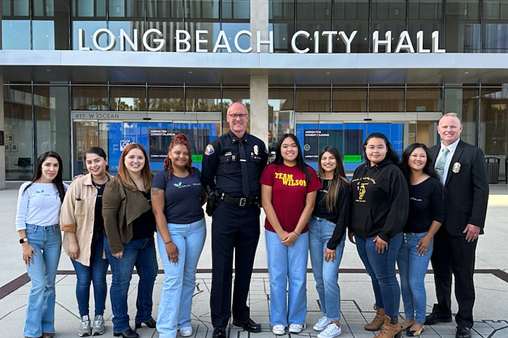 Jordan and Wilson high schools stand with representatives of Interval House and the Long Beach Police Department