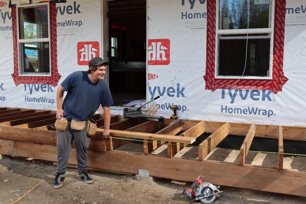 A person measures a deck.