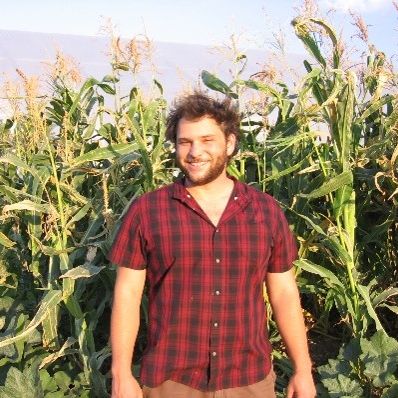 Fellow, Jack Earnest, smiling in front of corn stalks