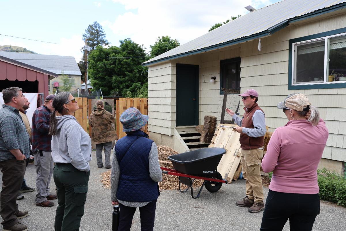 Group of people standing outside a home, observing a wildfire home risk assessment