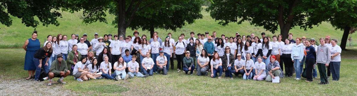 A group photo of 60+ Envirothon attendees smiling and wearing matching white/gray t-shirts.  