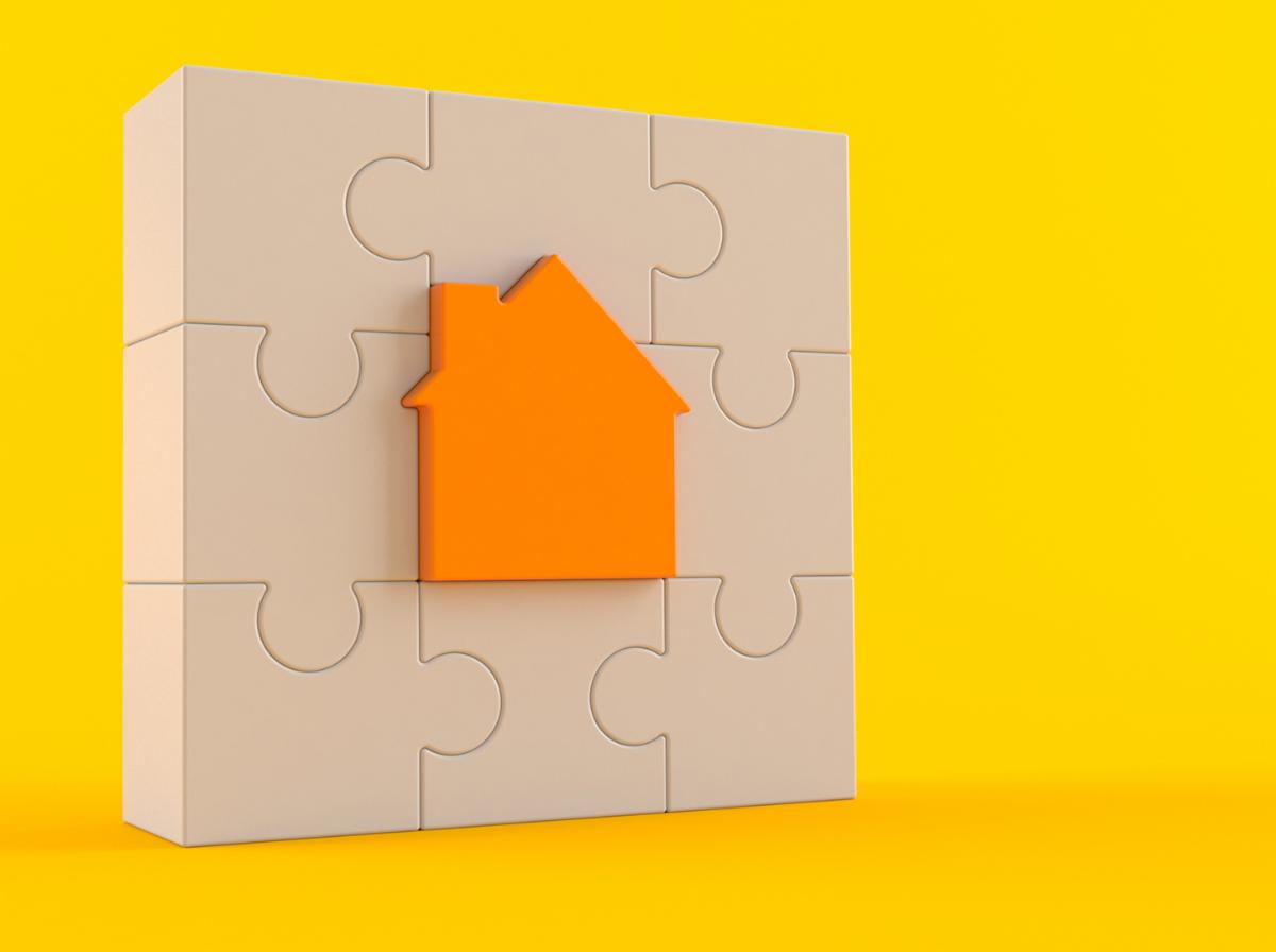 icon of a house in the center of a bunch of puzzle pieces