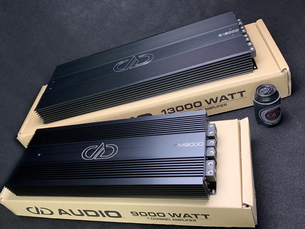 Photo of both Z13000 and M9000 monobock amps sittin on their packaging brown boxes on table view from top down of heatsinks logo an model names