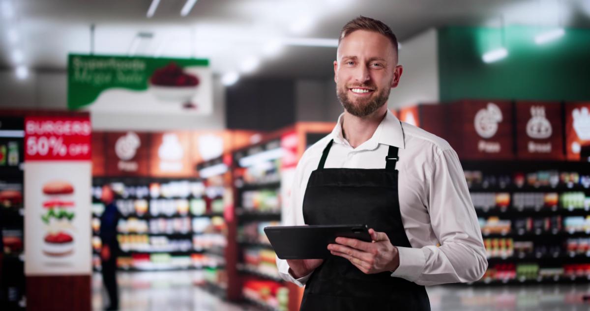 Supermarket Store Trainee Employee. Happy Man In Grocery Shop