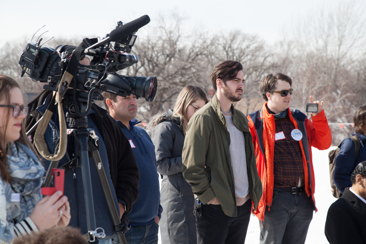 Community members and media gather for the ribbon cutting of a community solar garden on the roof of Shiloh Temple in North Minneapolis