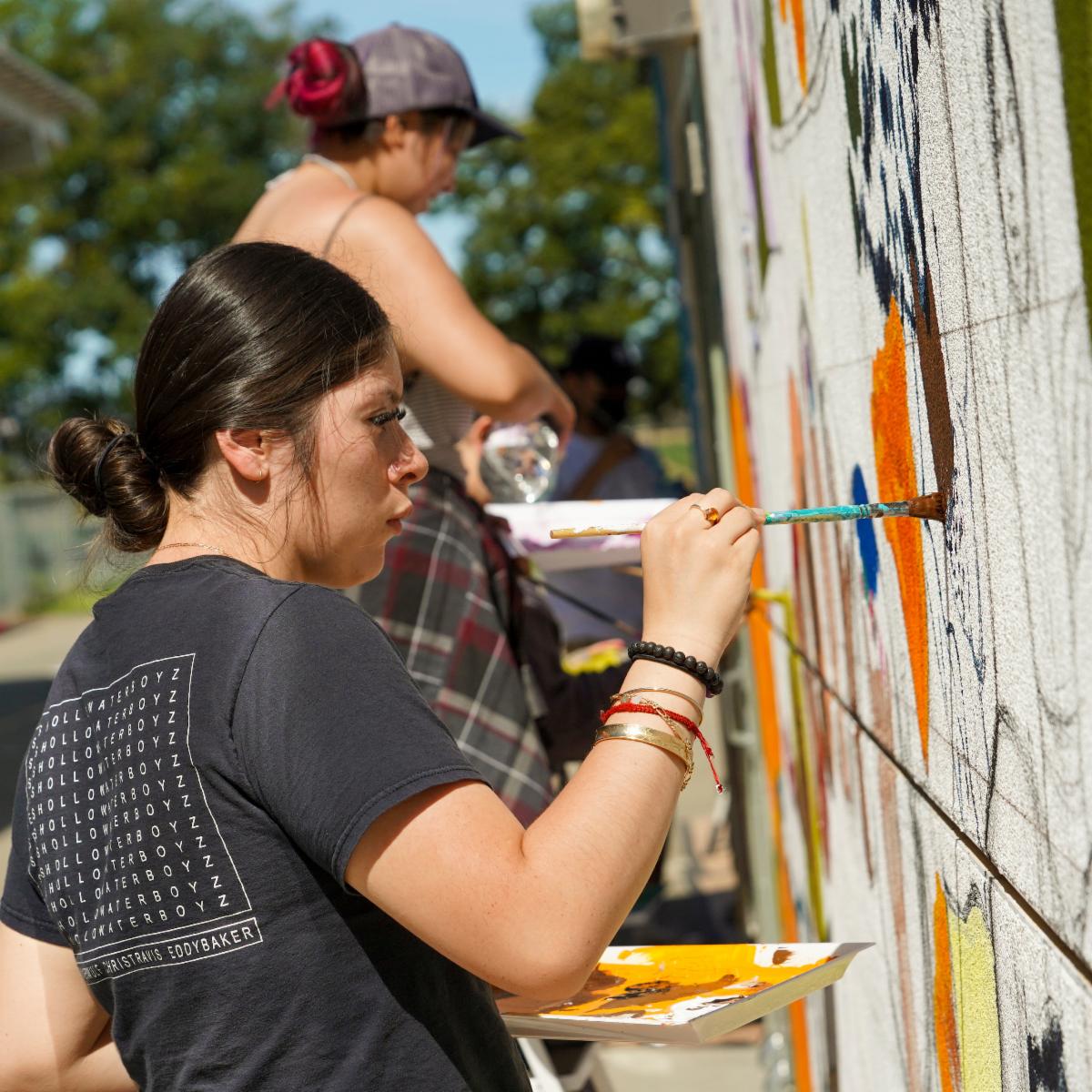 Students in the UC Davis Chicano Studies 171 mural workshop class work on a mural at Plainfield Elementary School in Woodland