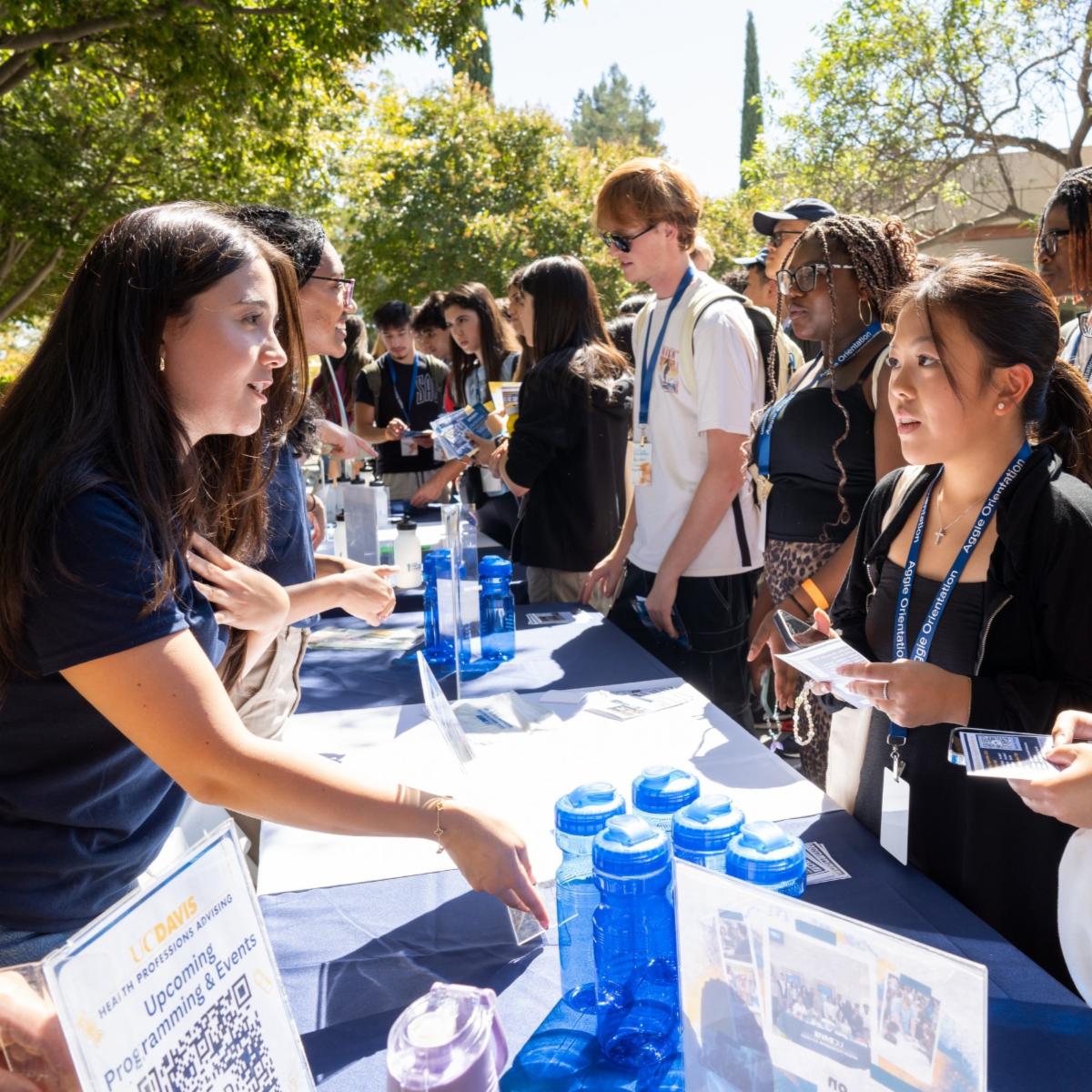 Image of an advisor from Health Professions Advising at UC Davis talking to a student at a tabling session