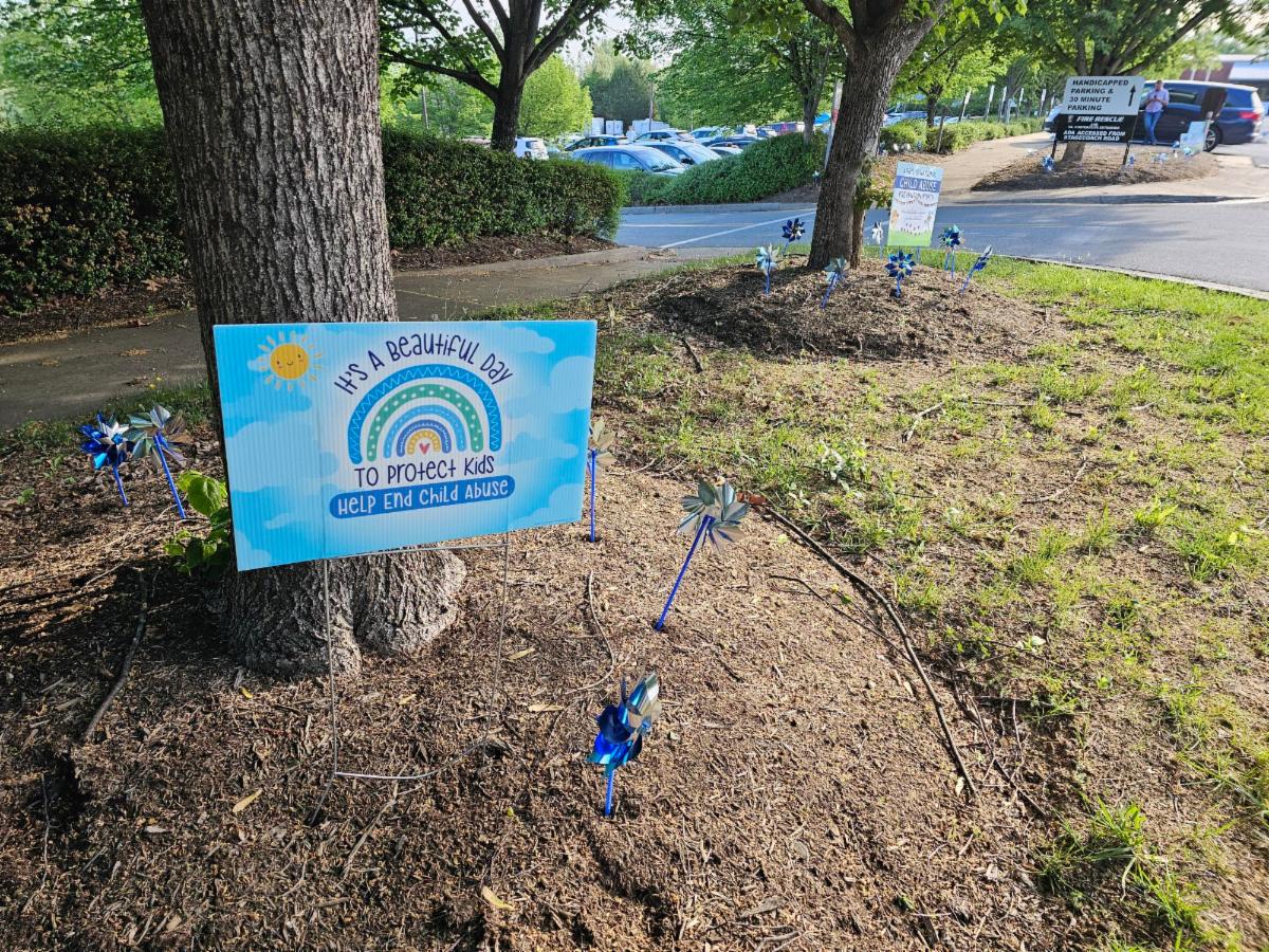 ACPD - Child Abuse Prevention Month - blue pinwheels in grass outside the County office building with signage