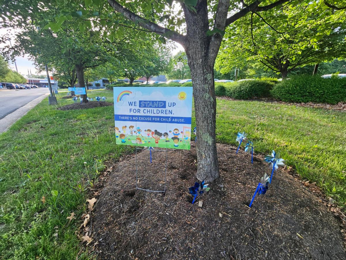 ACPD - Child Abuse Prevention Month - blue pinwheels in grass outside the County office building with signage