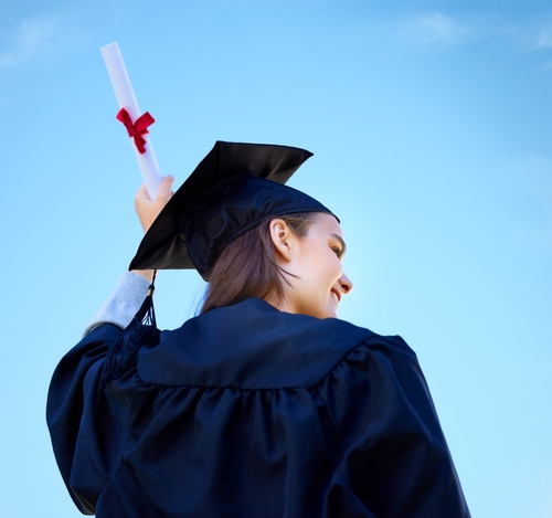 Woman_ student and diploma at outdoor graduation_ blue sky and proud of education celebration. Female person_ back and degree at college or university for achievement_ graduate and learning award