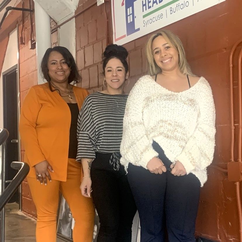 Three new employees lined up for a photo at HHQ