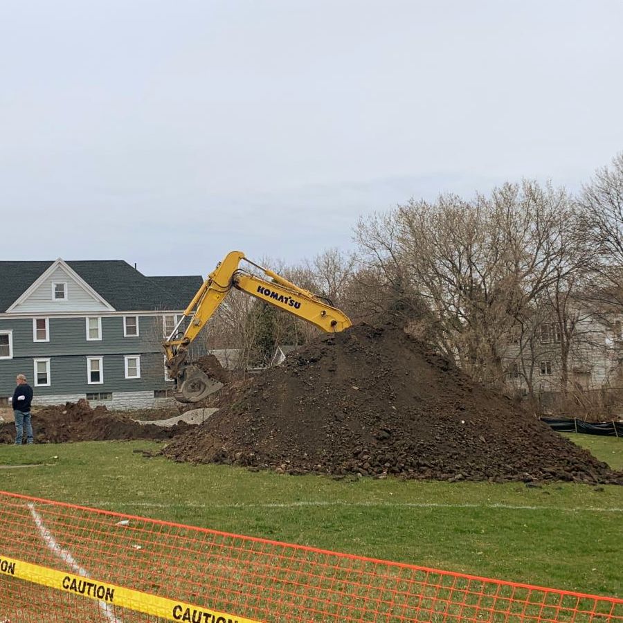 Big digger starting to dig a foundation in a large area of vacant land in Solvay, NY