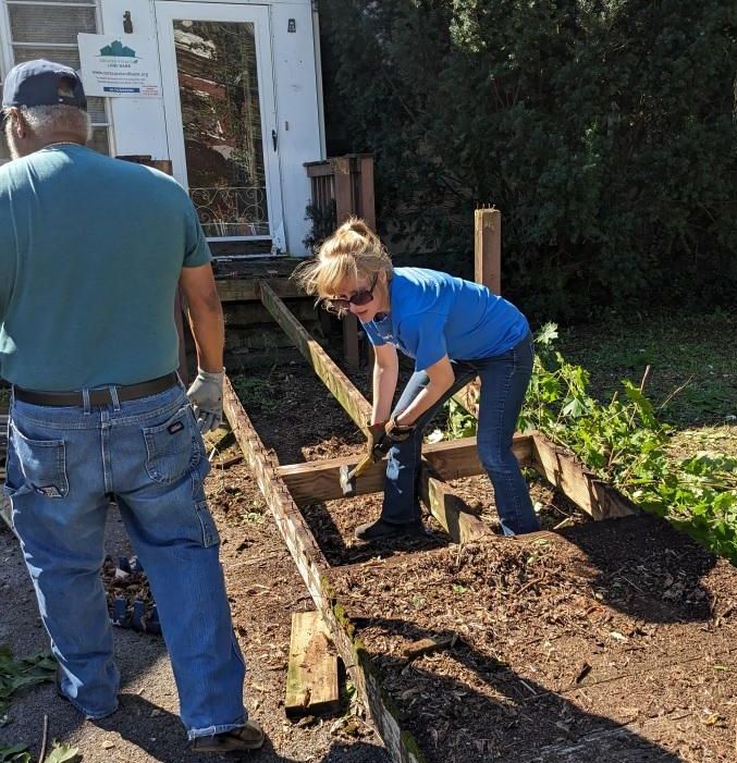 woman hammers away at a wooden ramp helping to remove it from a vacant house