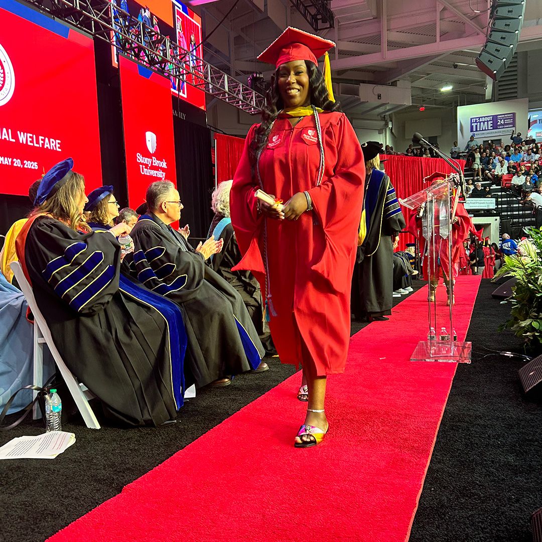 Graduate walking with diploma in her hand
