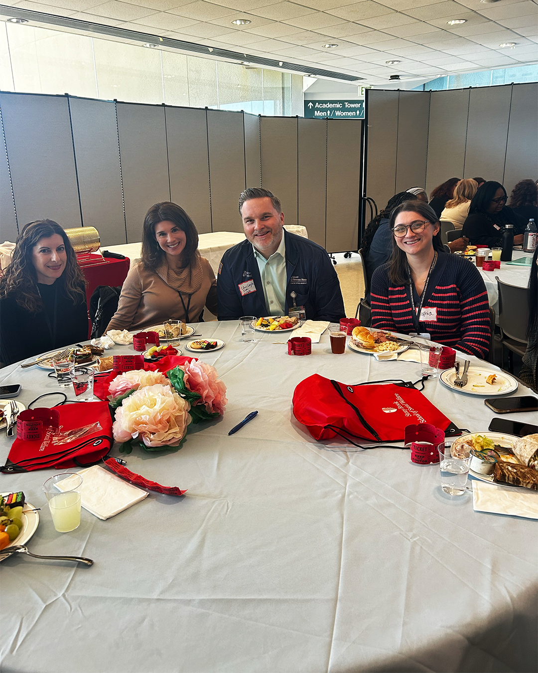Four people sitting at a table smiling.