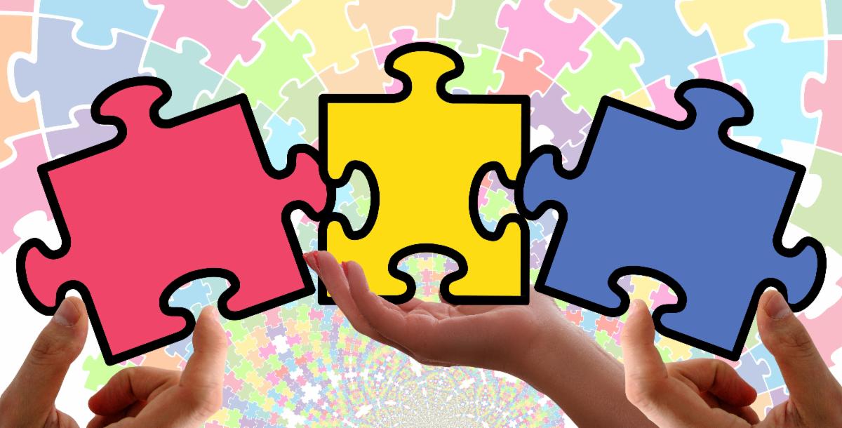 hands holding colored puzzle pieces 