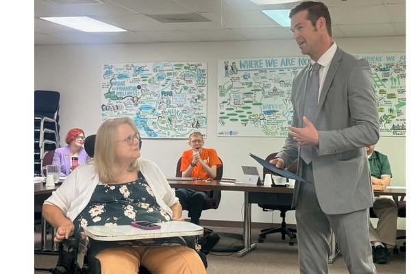 Ryan Croke presenting a letter from Governor Pritzker to Janinna Hendricks 