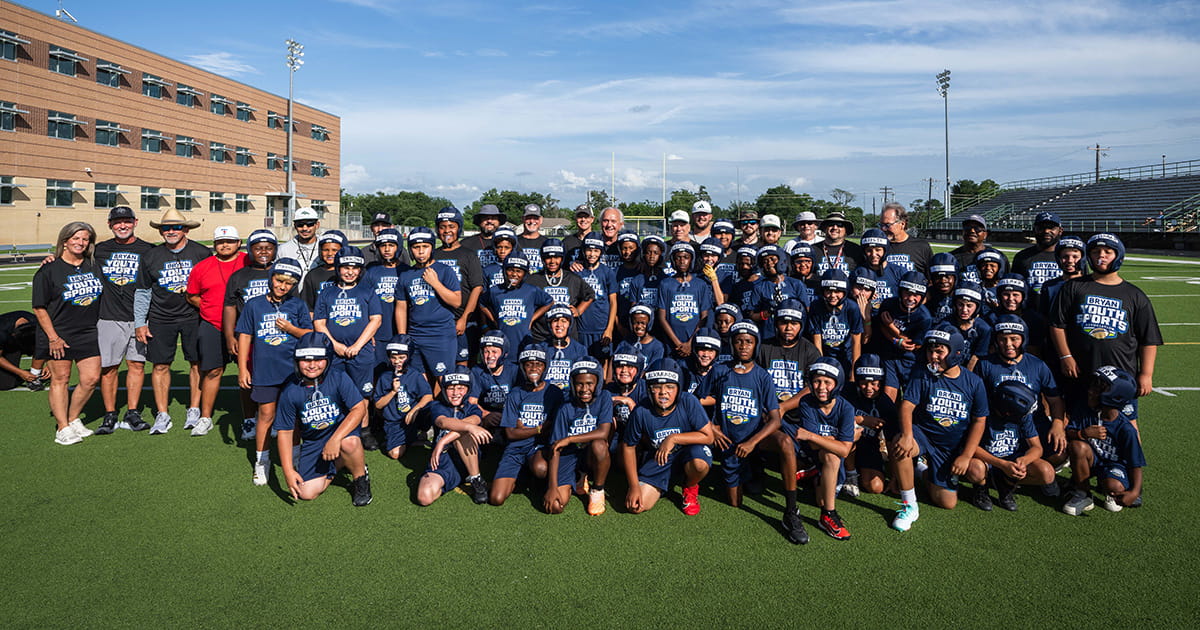 Coach Jackie Sherrill and the athletes from the Bryan Youth Sports Association's summer combine and mini-camp pose for a group photo.