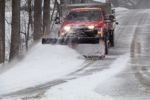 Snowplow in action clearing residential roads during snow storm