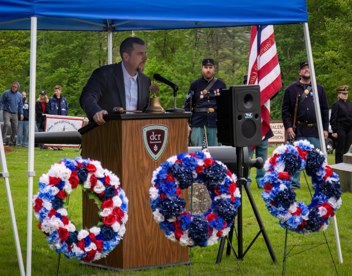 Photo of Veterans Agent speaking at podium outdoors at Quabbin Park Memorial Day Ceremony