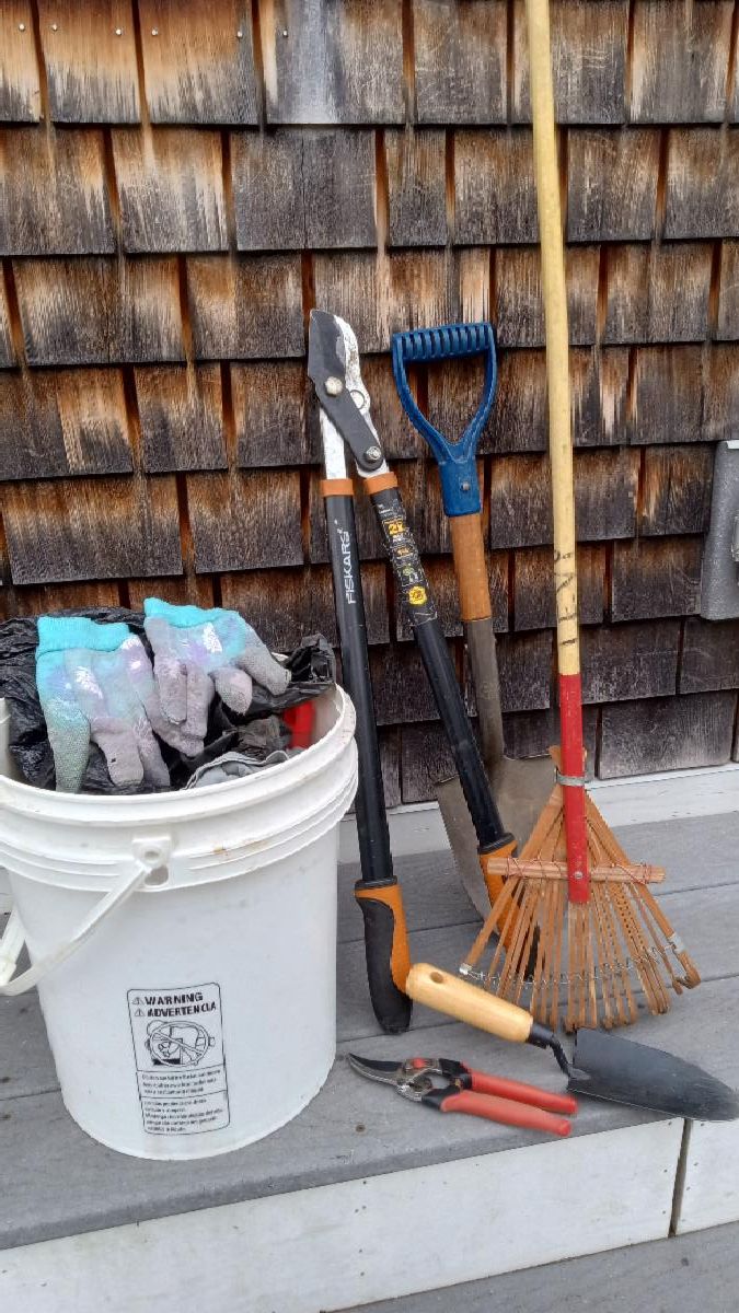 Photo of tools to clean up the trail including rake, loppers, a shovel, and others