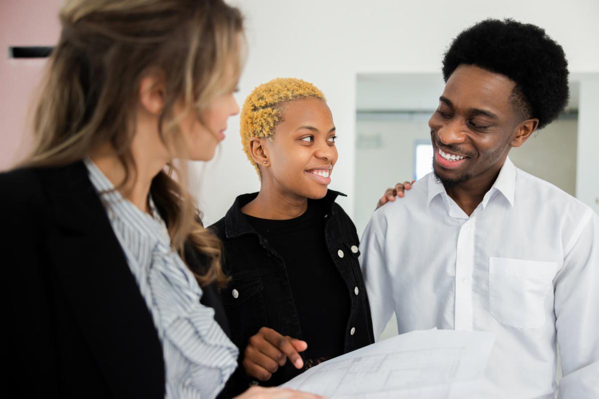 Blone young woman real estate agent showing the young couple several properties before they finally found their dream home. Getting mortgaged financial problems in debt concept.