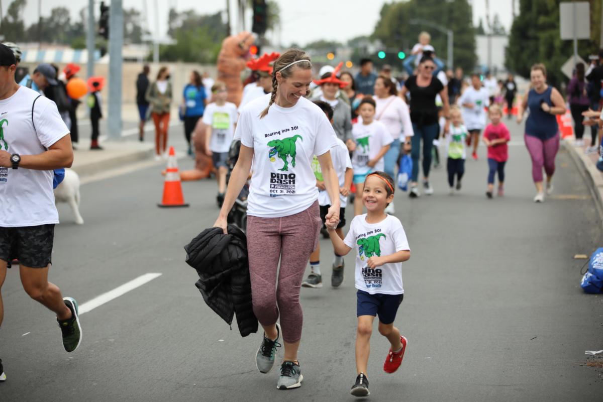 Two runners participate in the TSPF Dino Dash