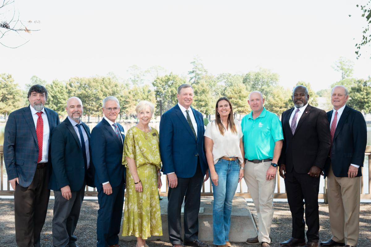 Group of people are taking a photo after a conference.