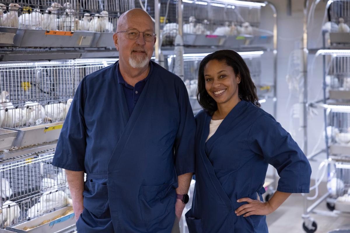 Billy Hargis stands with LaTasha Gray in front of some cages containing young turkeys