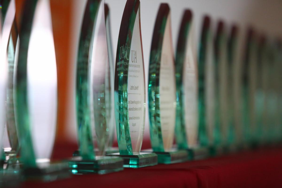 Awards displayed on a table, symbolizing recognition for outstanding achievements in various fields.