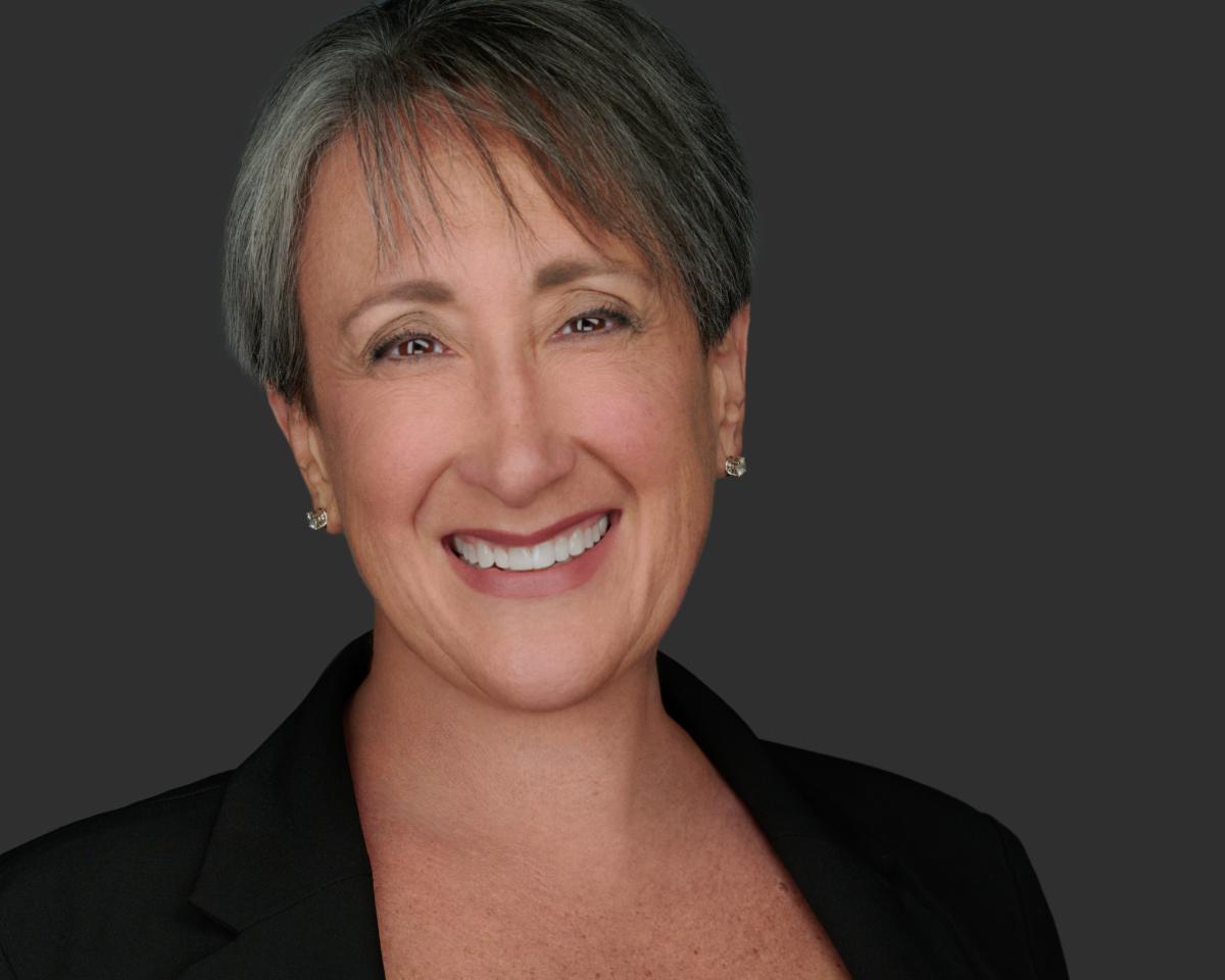 Professional storyteller Terry Wolfisch Cole, a smiling white woman with gray hair in a stylish short cut.