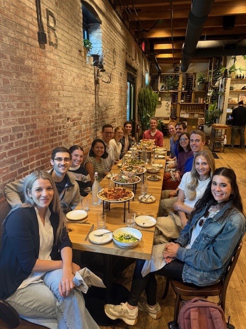 Dermatology faculty enjoying lunch at a restaurant table together.