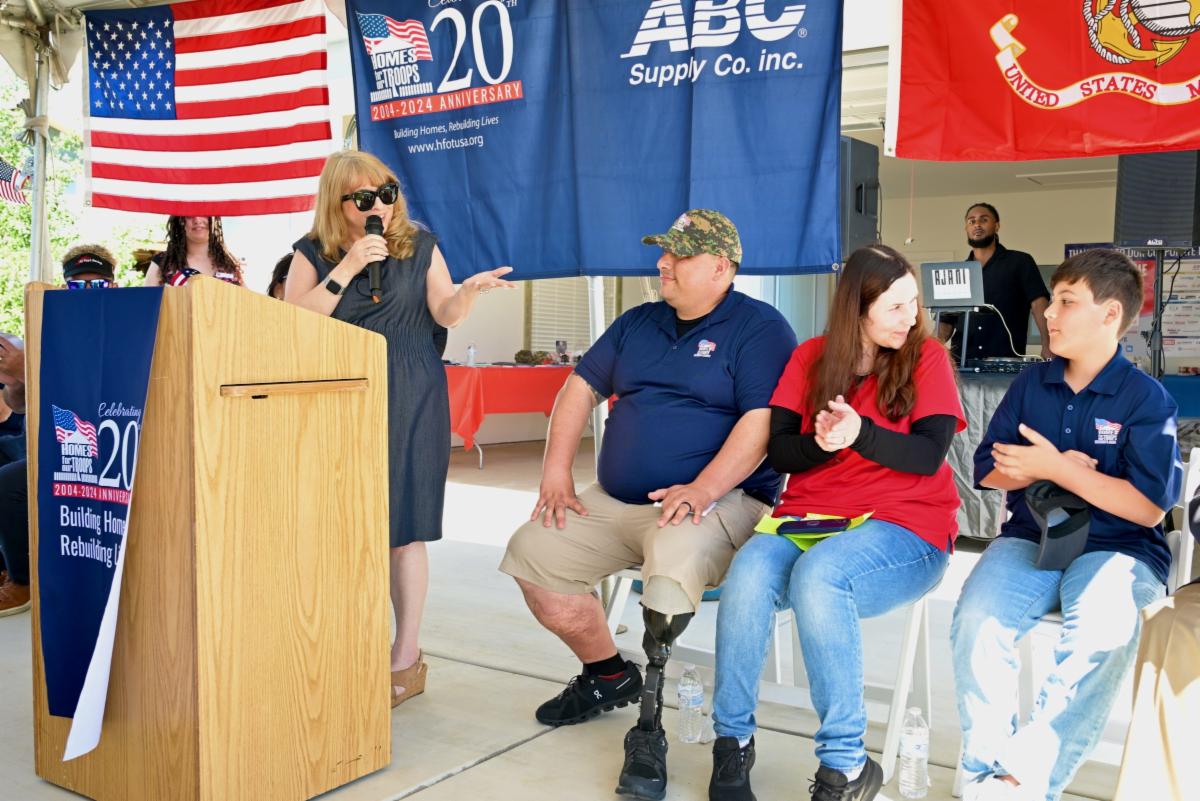 Supervisor Burgis speaking at a podium and addressing Kyle Garcia and his family