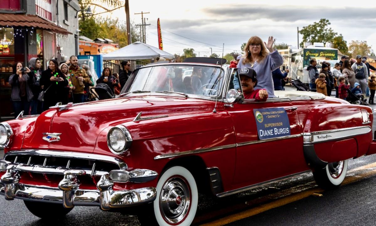 Supervisor Burgis waves from a 1954 Chevy Bel Air Convertible driven by George Serano
