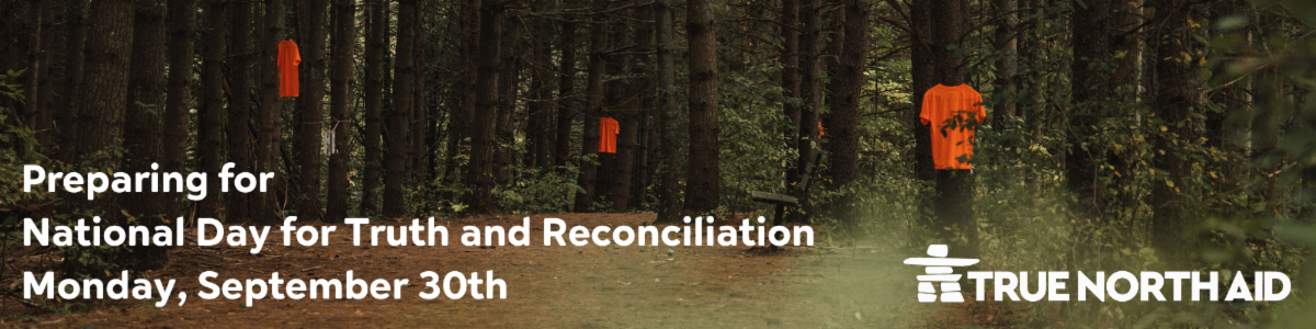 Photo of orange t-shirts hung on tree branches. Preparing for National Day for Truth and Reconciliation.
