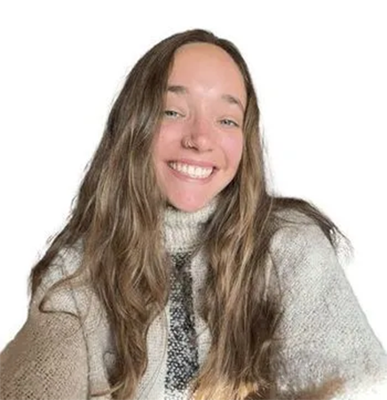 A young woman with long wavy brown hair smiles warmly at the camera. She is wearing a cozy, light-colored turtleneck sweater, and the background is a clean white.