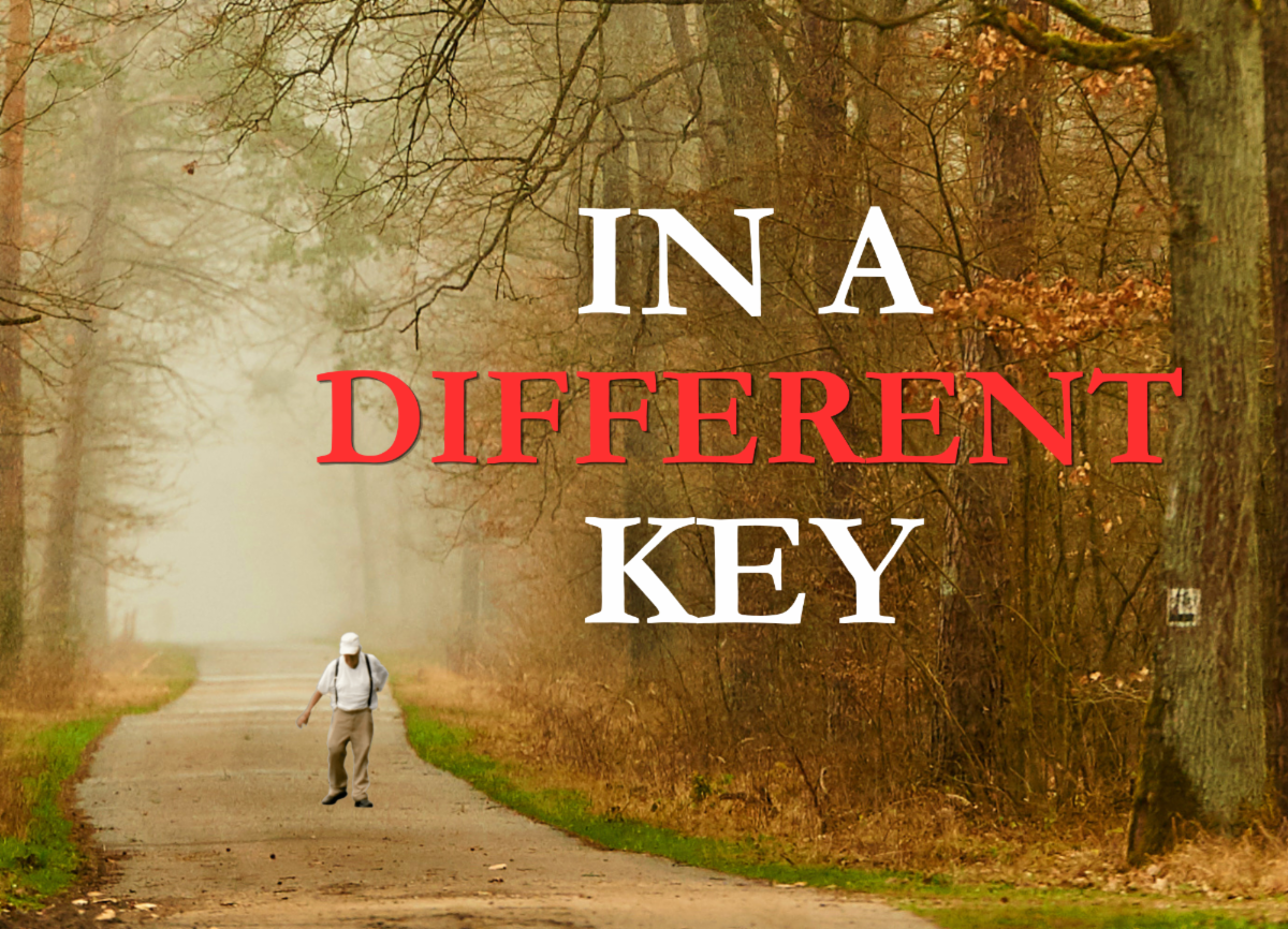 A foggy forest path stretches into the distance as an older man wearing a white hat, white shirt, and tan pants walks along the road. Large text over the image reads, âIN A DIFFERENT KEY.â