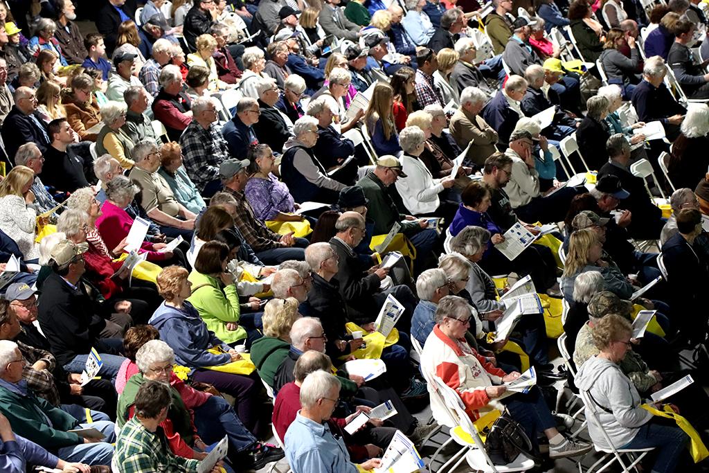 A crowd of people sit in chairs
