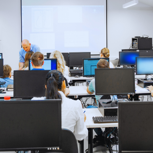 Instructor in front of students in a computer lab