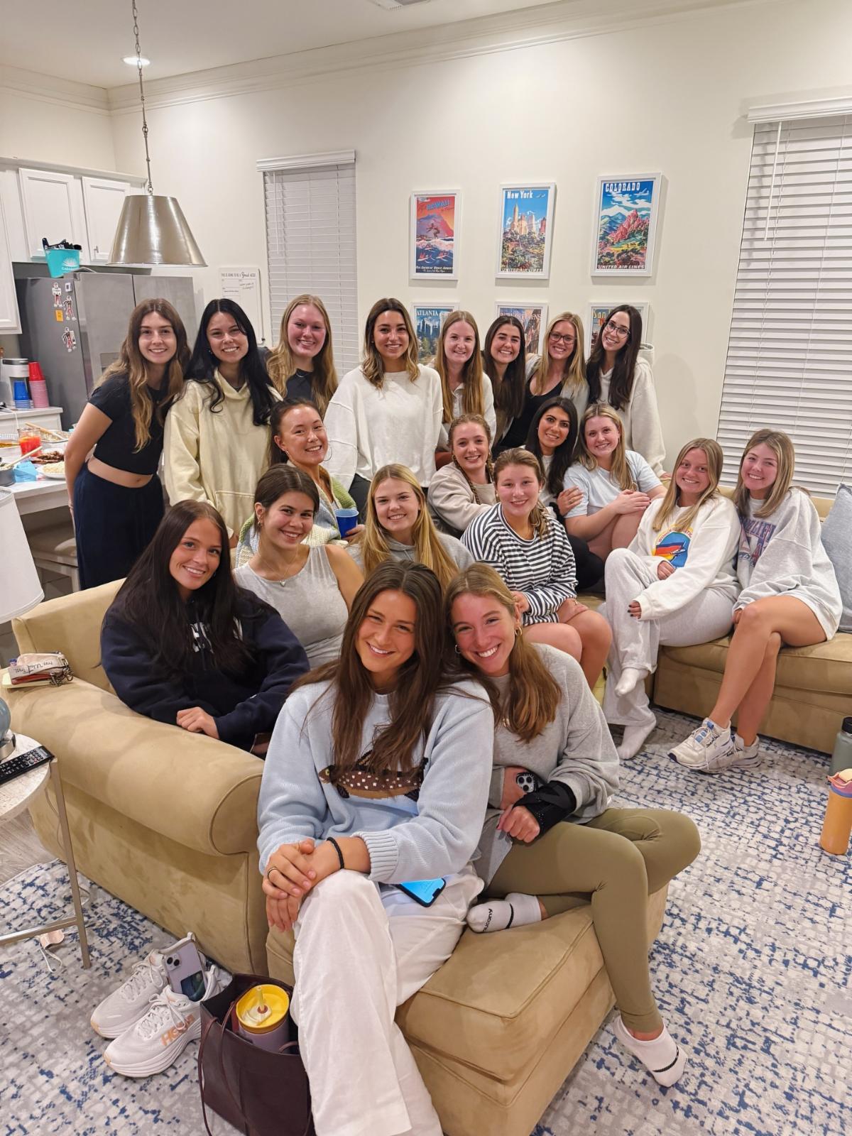 Auburn Ninety Nines members gather together on couches and smile up at  the camera