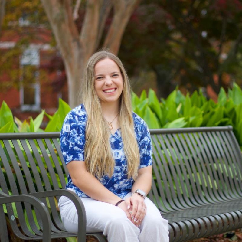 Kyla Hampson smiling on a bench