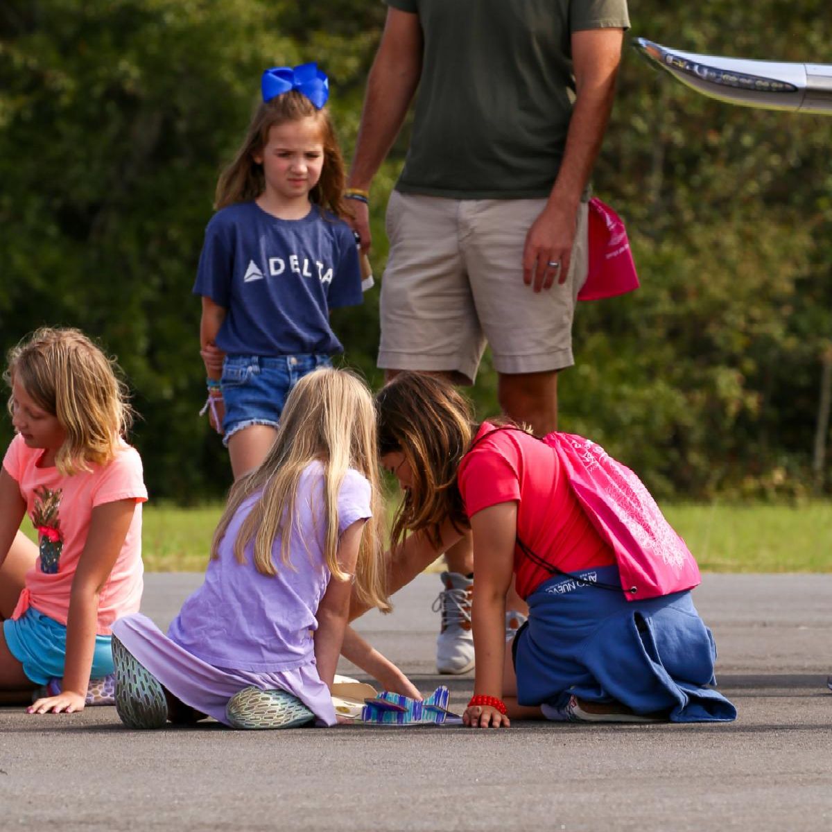 Four Striped Wing Ambassadors stand in front of a Boeing Aircraft