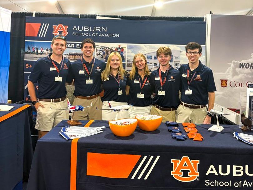 Six Striped Wing Ambassadors stand proudly repping the School of Aviation at Osh Kosh