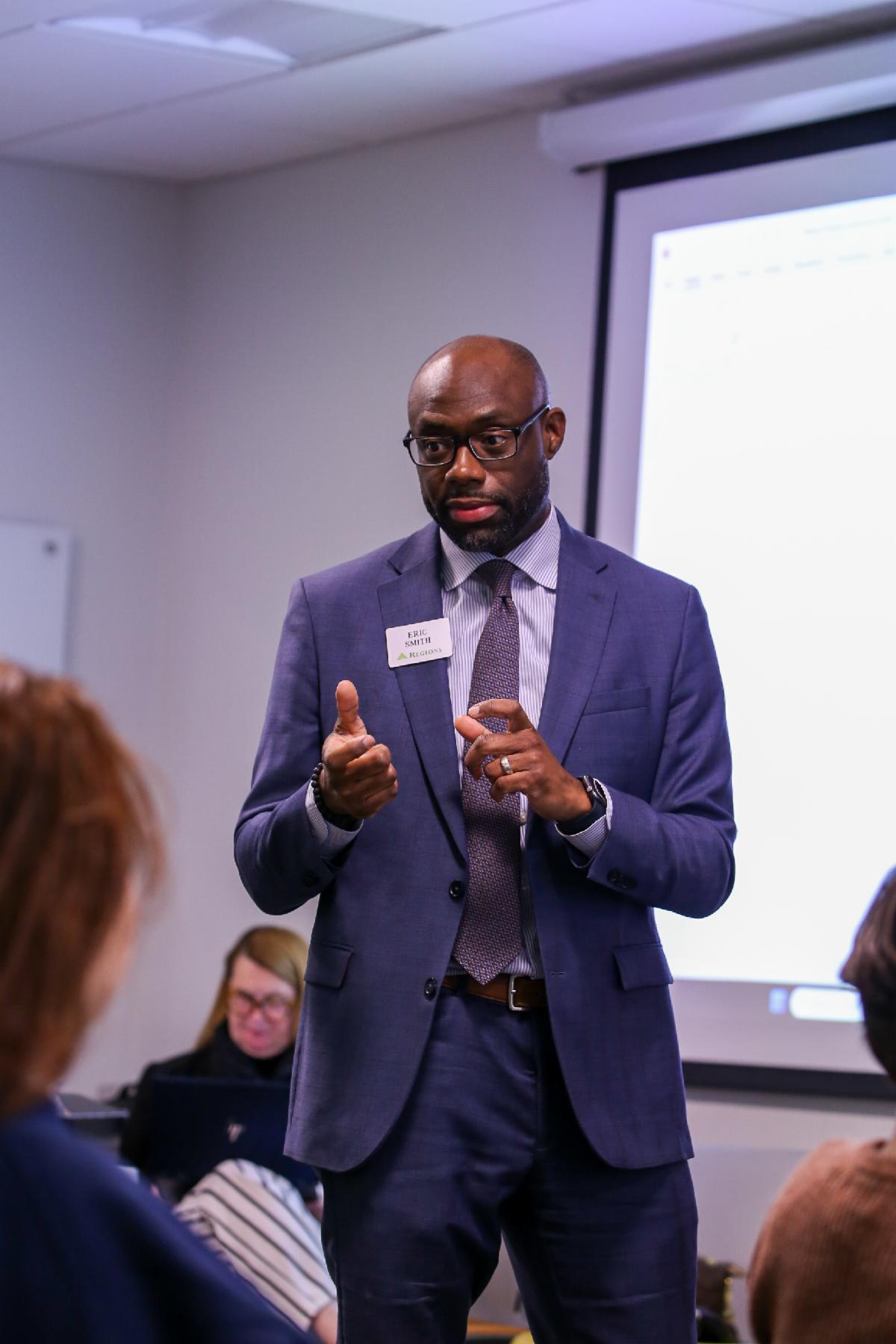 Regions Ambassador, Eric Smith discusses topics with students in foreground.