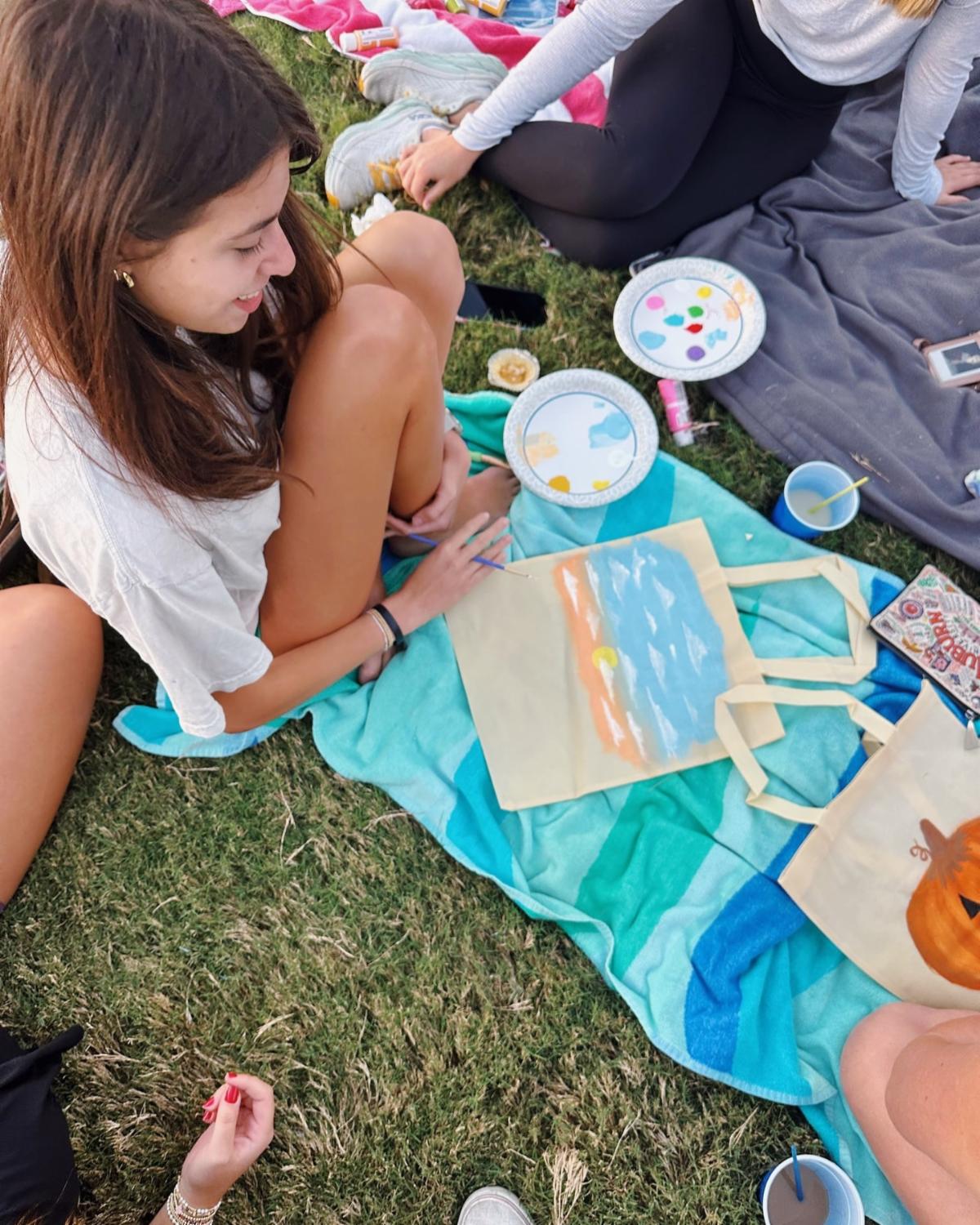 Auburn Ninety-Nines members paint tote bags on grass