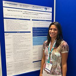 Doctoral student Ila Iverson stands next to her poster to be presented in Dublin, Ireland