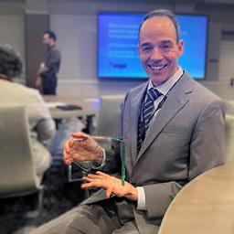 Dr. Shawn McClintock holding his ISEN Award
