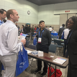 four people chatting around a table with handouts