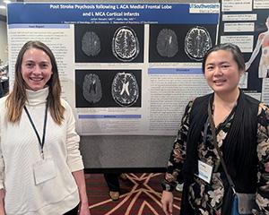Jaclyn Hozumi (left) and Kathy Niu stand in front of a poster at the American Neuropsychiatric Association event in March