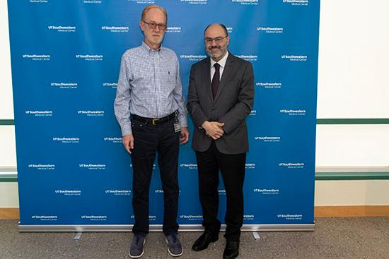 Two people stand next to each other in front of a backdrop that reads UT Southwestern Medical Center